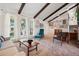 Inviting living area with exposed beams, large windows, cozy seating, and an open floor plan at 3832 S Quebec St, Denver, CO 80237