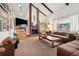 Spacious living room featuring brick fireplace and wooden ceiling beams at 3832 S Quebec St, Denver, CO 80237