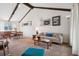 Inviting living room with vaulted ceiling, wooden beams, neutral tones, and comfortable furnishings at 3832 S Quebec St, Denver, CO 80237