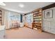 Well-lit office with built-in bookshelves, large window, and neutral tones at 3832 S Quebec St, Denver, CO 80237