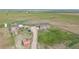 Aerial view of a red home and several red outbuildings on a large lot at 66095 E Kettle Pl, Byers, CO 80103