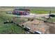 Aerial shot of a red home, corral, and surrounding acreage at 66095 E Kettle Pl, Byers, CO 80103