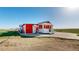 Quaint red house featuring a covered porch and surrounding landscape, offering a peaceful retreat at 66095 E Kettle Pl, Byers, CO 80103