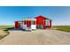 Bright red home with a covered porch and stamped concrete driveway at 66095 E Kettle Pl, Byers, CO 80103