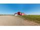 Exterior view of a red house, set on a lot with expansive land and clear blue sky at 66095 E Kettle Pl, Byers, CO 80103
