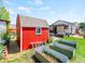 Backyard featuring a red storage shed, three metal gardening beds, and the main house in the background at 4163 S Decatur St, Englewood, CO 80110