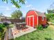 Red storage shed with a table, chairs, and colorful rug on the outdoor patio at 4163 S Decatur St, Englewood, CO 80110
