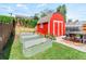 Backyard with a red shed, metal gardening beds, and a small greenhouse at 4163 S Decatur St, Englewood, CO 80110
