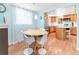 Bright dining area adjacent to the kitchen with hardwood floors and ample seating around a round table at 4163 S Decatur St, Englewood, CO 80110