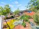 Well-manicured front yard showcasing colorful flower beds and a charming brick home with blue shutters at 4163 S Decatur St, Englewood, CO 80110