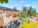 Brick home featuring a beautifully landscaped front yard with colorful flowers and mature trees at 4163 S Decatur St, Englewood, CO 80110