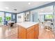 Open kitchen with wood island, white countertop, view to dining room with white chairs and blue walls at 4163 S Decatur St, Englewood, CO 80110