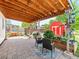 Covered brick patio with outdoor seating, colorful rug, and a glimpse of the shed in the background at 4163 S Decatur St, Englewood, CO 80110