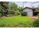 Backyard featuring healthy lawn, garden boxes, mature landscaping, and house with gray siding at 1694 S Elm St, Denver, CO 80222