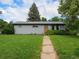 Single-story home with a walkway leading to an inviting wooden front door at 1694 S Elm St, Denver, CO 80222