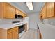 Efficient kitchen featuring light wood cabinets, tile flooring, and white appliances at 2682 S Benton St, Lakewood, CO 80227