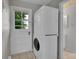 Laundry room with stackable washer/dryer next to back door with window, tile flooring at 2682 S Benton St, Lakewood, CO 80227