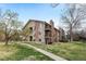 Multi-story condo featuring private balconies, brick accents, and mature trees at 3021 S Ursula Cir # 102, Aurora, CO 80014