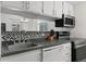 A well-maintained kitchen with updated appliances and black and white tile backsplash at 3021 S Ursula Cir # 102, Aurora, CO 80014