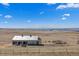 Horse barn featuring stalls, storage areas, and a picturesque backdrop of rolling hills and distant mountains at 7600 Patrick Trl, Elizabeth, CO 80107