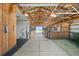 Spacious barn interior featuring well-maintained stalls, wooden beams, and ample lighting for livestock comfort and care at 7600 Patrick Trl, Elizabeth, CO 80107