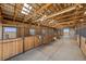 Well-maintained horse barn interior showcasing multiple stalls with wooden dividers and a bright, open layout at 7600 Patrick Trl, Elizabeth, CO 80107