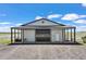 Exterior shot of horse barn featuring an overhang, large doors, and white siding at 7600 Patrick Trl, Elizabeth, CO 80107