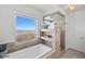 Bathroom with a large soaking tub and a window offering a scenic view at 7600 Patrick Trl, Elizabeth, CO 80107