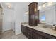 Bathroom with a double vanity, granite countertop, dark wood cabinets, and decorative lights at 7600 Patrick Trl, Elizabeth, CO 80107