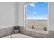 Bright bathroom featuring a modern tub, tiled walls, and a serene view from the window at 7600 Patrick Trl, Elizabeth, CO 80107