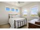 Sunlit bedroom with a brass bed frame, light wood floors, and multiple windows for ample natural light at 7600 Patrick Trl, Elizabeth, CO 80107
