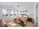 Bright bedroom featuring hardwood floors, many windows, and a ceiling fan at 7600 Patrick Trl, Elizabeth, CO 80107
