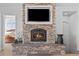 Stone fireplace with mounted TV and a view into the main bedroom offering an elegant design element at 7600 Patrick Trl, Elizabeth, CO 80107
