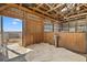 Interior horse stall featuring wood paneling, sand flooring, water trough, and open doorway for easy access at 7600 Patrick Trl, Elizabeth, CO 80107