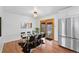 Dining room with a glass table, six chairs, stainless steel refrigerator, and wood floors at 1325 S Grape St, Denver, CO 80222