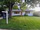Well-kept front yard showcasing a charming white home with a manicured lawn and mature tree at 1325 S Grape St, Denver, CO 80222