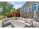 A stone patio with comfortable seating, a grill, an umbrella, and a charming deck are set for entertaining at 9576 E 147Th Pl, Brighton, CO 80602