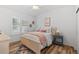 Bedroom with white walls, wood floors, ceiling fan, and a window with white shutters at 9576 E 147Th Pl, Brighton, CO 80602