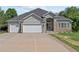 Charming home exterior featuring a stone facade, three-car garage, and well-maintained landscaping at 9576 E 147Th Pl, Brighton, CO 80602