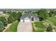 An aerial view showcasing a home's manicured front lawn, long driveway, and spacious three-car garage at 9576 E 147Th Pl, Brighton, CO 80602