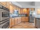 Kitchen with wood cabinets, stainless steel appliances, and wood flooring at 9576 E 147Th Pl, Brighton, CO 80602