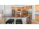 Kitchen with wood cabinets, stainless steel appliances, and large center island with bar stools at 9576 E 147Th Pl, Brighton, CO 80602