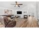 Cozy living room featuring a fireplace, large television, ceiling fan, and wood-look flooring at 9576 E 147Th Pl, Brighton, CO 80602