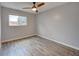 This bedroom features neutral paint, an oversized window, and vinyl floors at 16349 E Radcliff Pl # B, Aurora, CO 80015