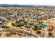 Expansive aerial view of a community with manicured lawns, mature trees, and a tennis court at 16118 Peregrine Dr, Parker, CO 80134