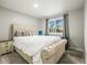 Bedroom featuring a tufted headboard, neutral colors, and a window at 16118 Peregrine Dr, Parker, CO 80134