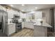 Kitchen with white cabinetry, stainless appliances, granite counters and wood-look flooring at 16118 Peregrine Dr, Parker, CO 80134