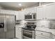 Bright kitchen featuring stainless steel appliances, granite countertops, and white cabinetry at 16118 Peregrine Dr, Parker, CO 80134