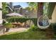 Landscaped backyard with a dining table, large shade tree, and hanging lounge chairs at 141 N Gilpin St, Denver, CO 80218