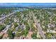 Expansive aerial of a residential community, lush greenery, and a tranquil lake creating a serene suburban landscape at 4883 Perry St, Denver, CO 80212